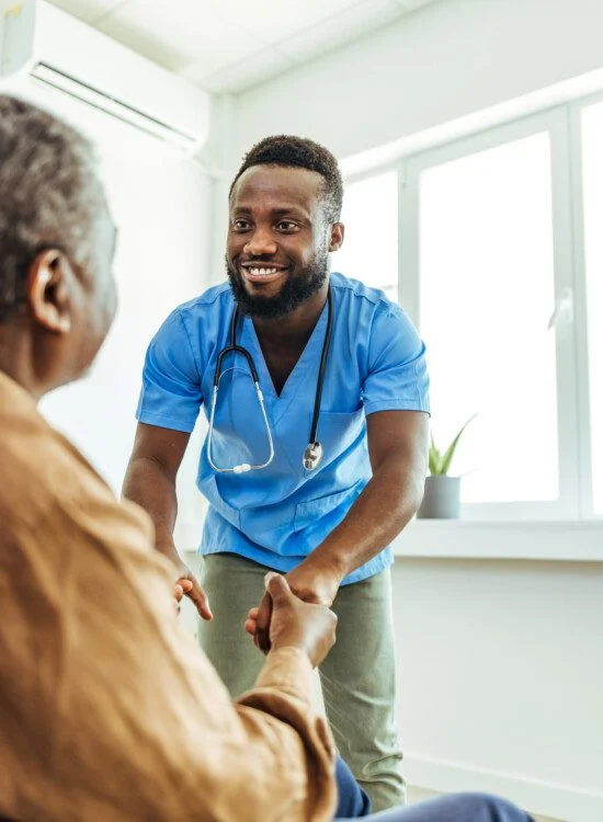 Healthcare worker assisting patient in a bright room.