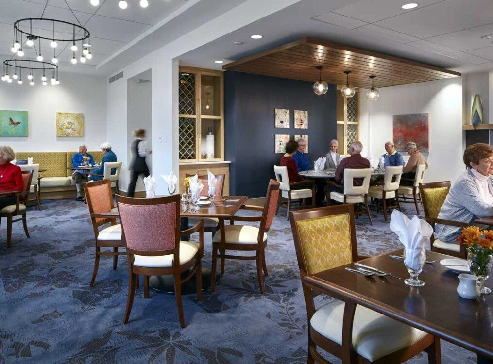 People dining in a modern restaurant with vibrant decor and ample lighting.