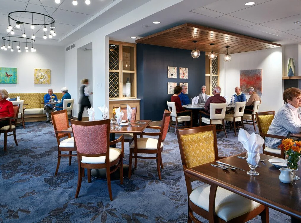 People dining in a well-lit restaurant with modern decor and artwork on walls.