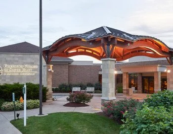 Entrance to Friendship Village of South Hills with a modern canopy and landscaped garden.