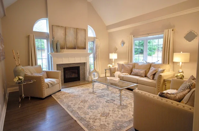 Spacious living room with beige furniture, fireplace, and large windows.