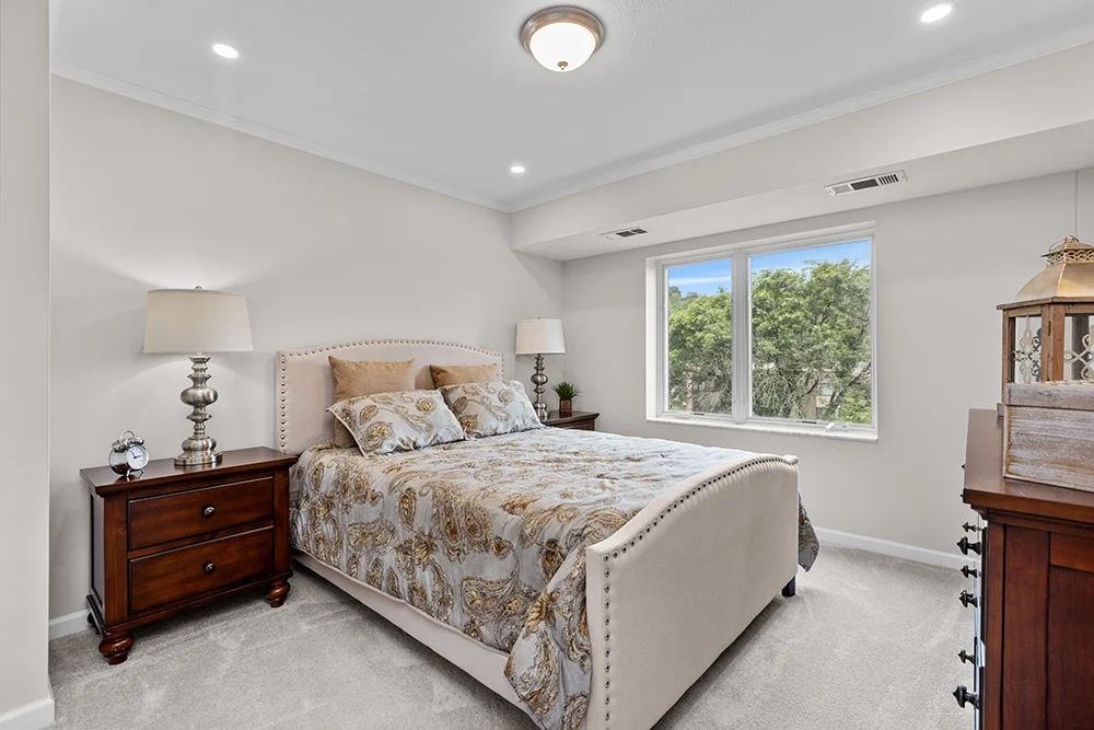 Elegant bedroom with a double bed, nightstands, and a window view.