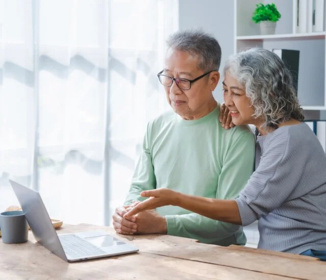 senior couple review their finances while exploring senior living options on their laptop