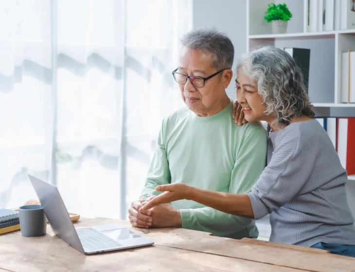 senior couple review their finances while exploring senior living options on their laptop