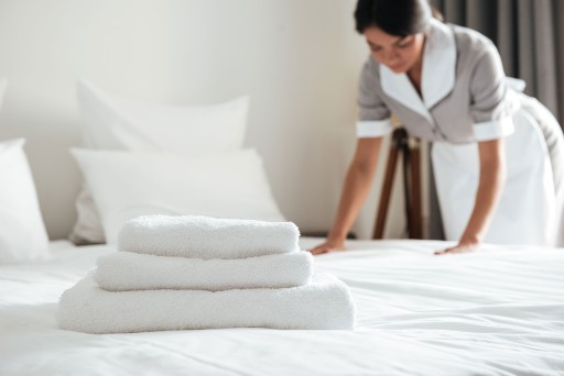 woman putting bedding on a bed